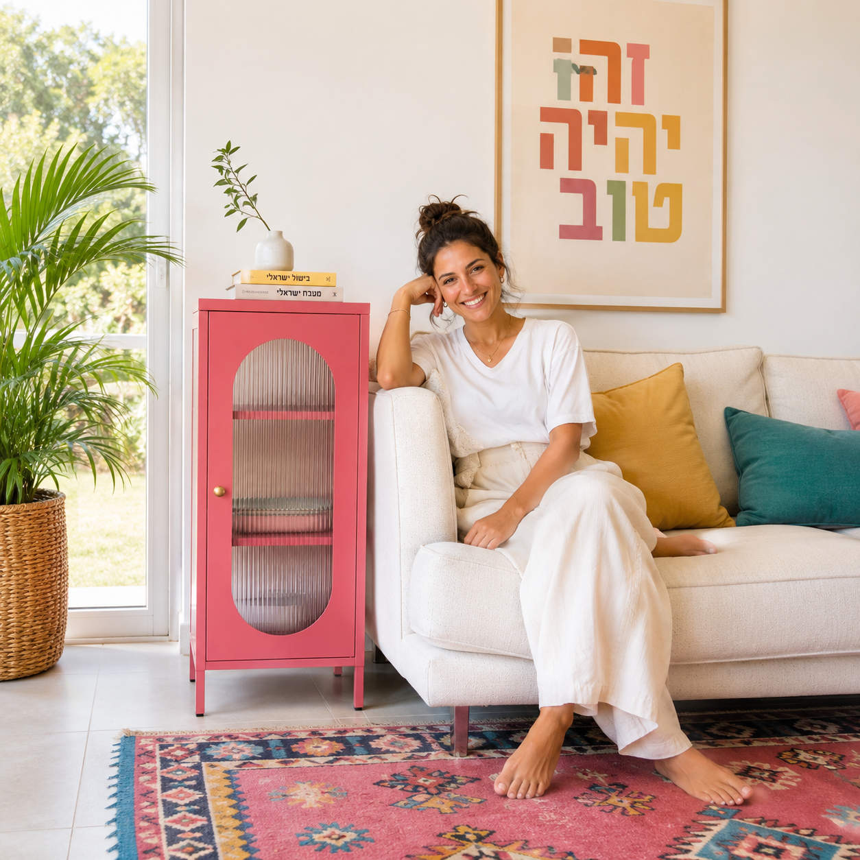 מזנון בצבע קורל עם דלת זכוכית מפוספסת בסלון ביתי צבעוני, לצד ספה וכריות